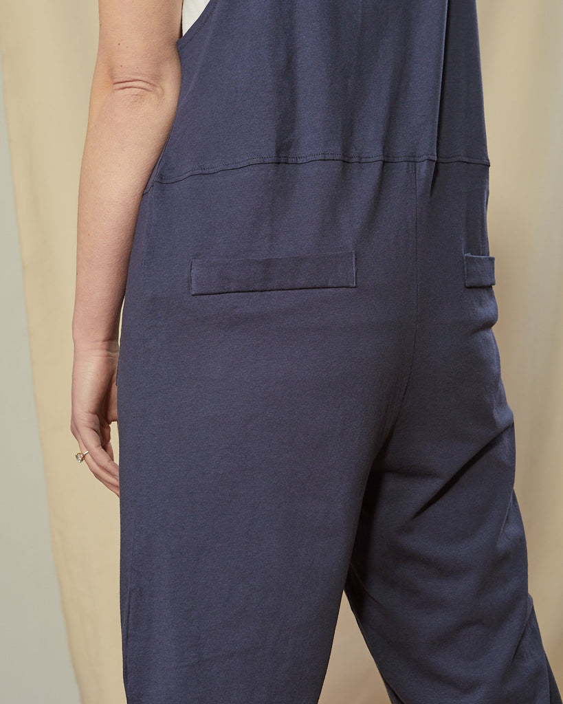 Close-up angled back shot of cotton jersey navy-blue Jumpsuit for women clearly showing back pockets.