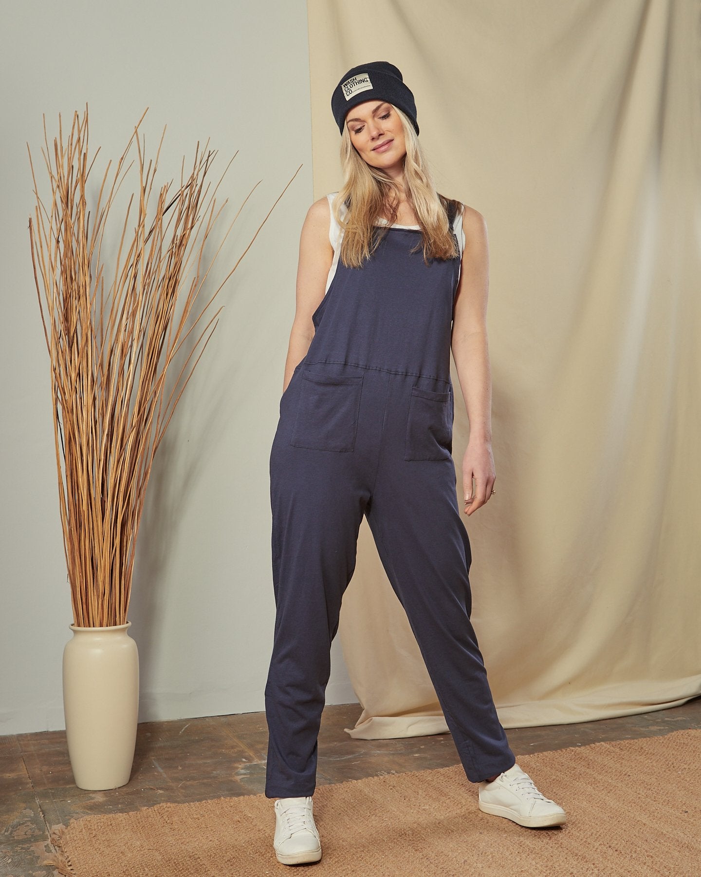 Full-length front shot of slightly stretchy jersey all-in-one navy-blue Jumpsuit clearly showing two front hip pockets.