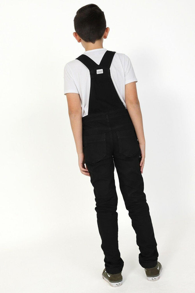 Full rear pose at a slightly diagonal angle, wearing modern style dungarees showing adjustable straps and belt loops.