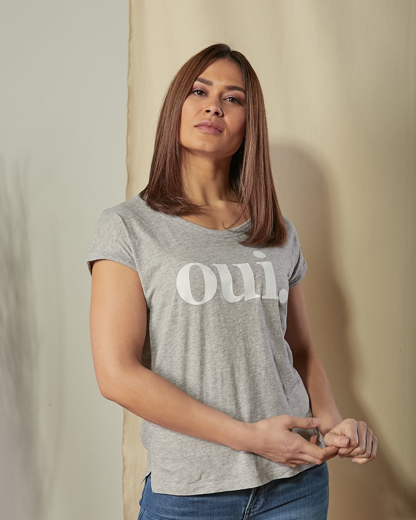 Close-up view of model wearing 'Oui' motif organic ringspun combed cotton t-shirt in grey.