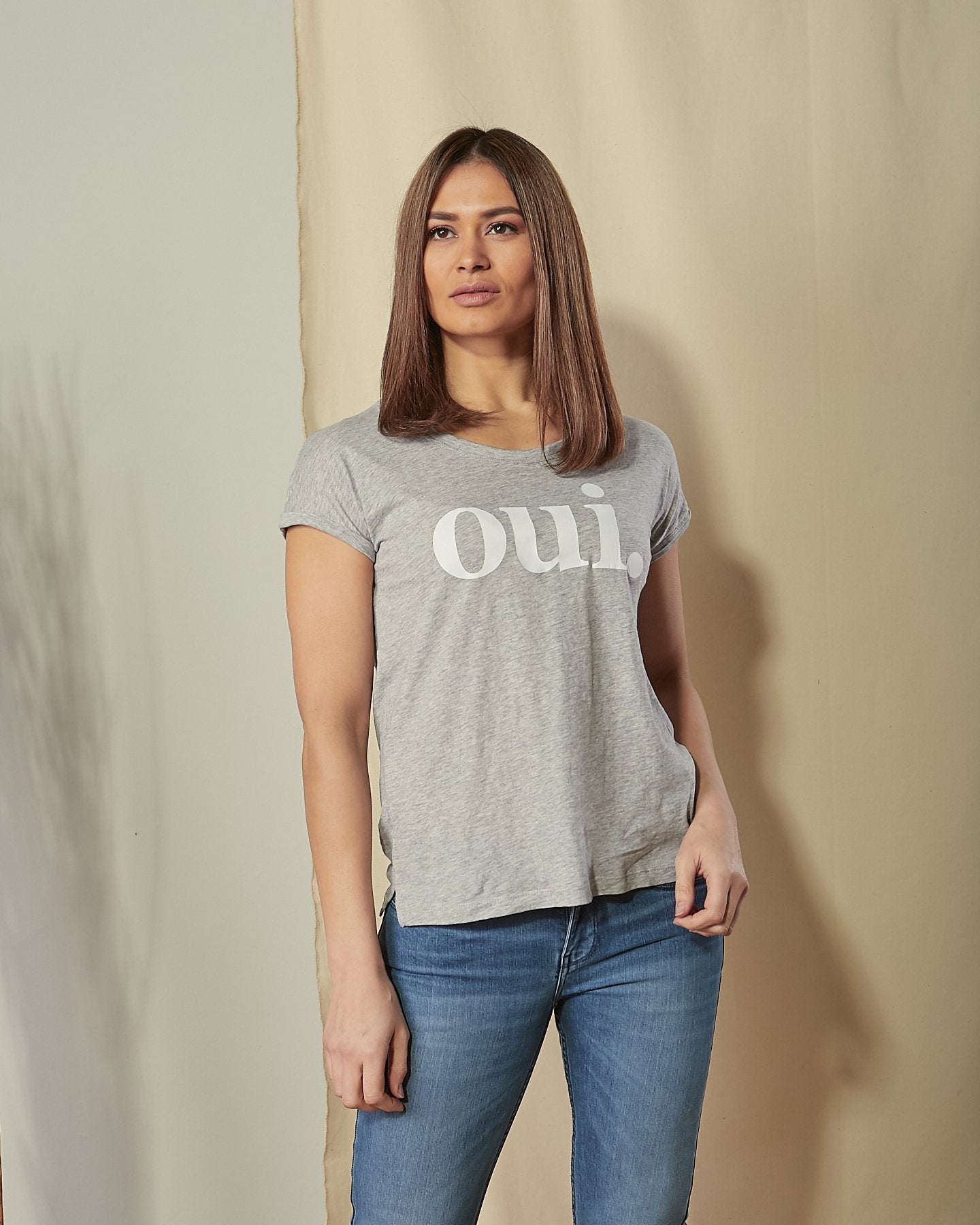 Two-thirds length front view of model wearing 'Oui' motif t-shirt in grey.