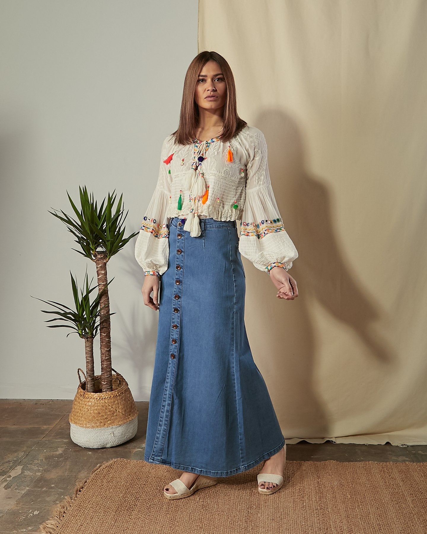 Angled full-length front shot of model wearing Peggy button front flared maxi denim skirt.