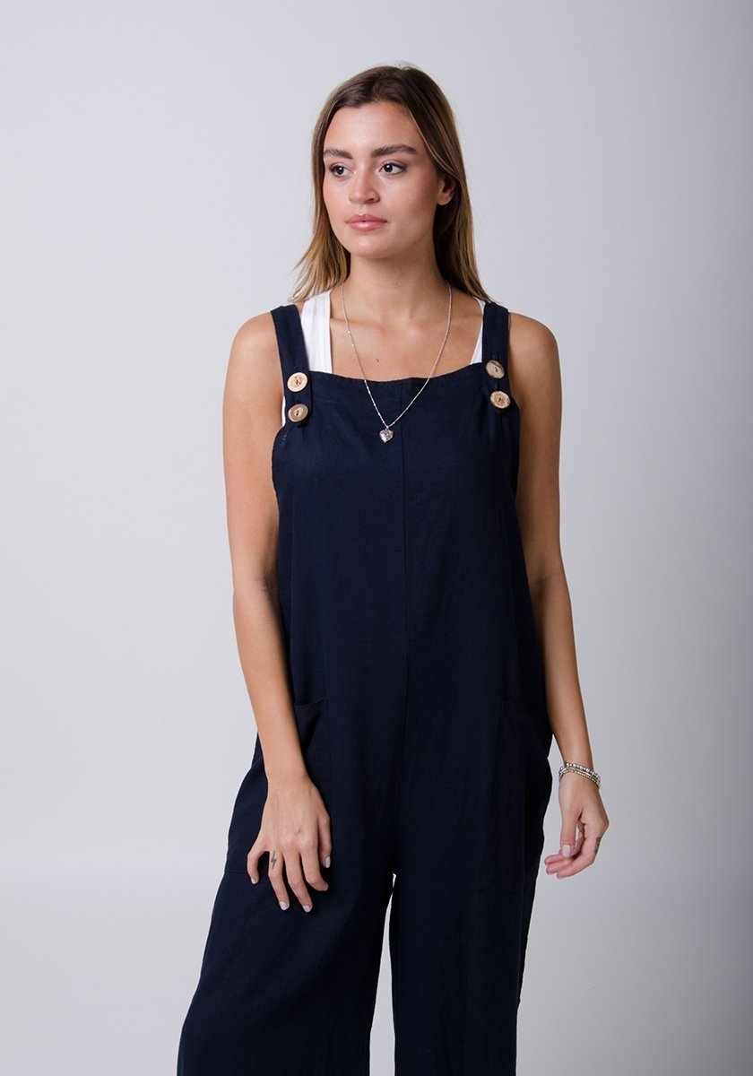 Two-thirds front view showing adjustable button straps of Saffy-style loose fit navy-blue overalls.