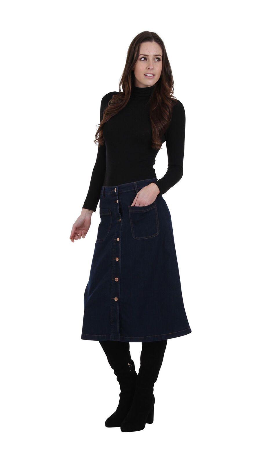 Angled frontal view leaning on right hip with hand in front-left patch pocket of dark denim button-front skirt.