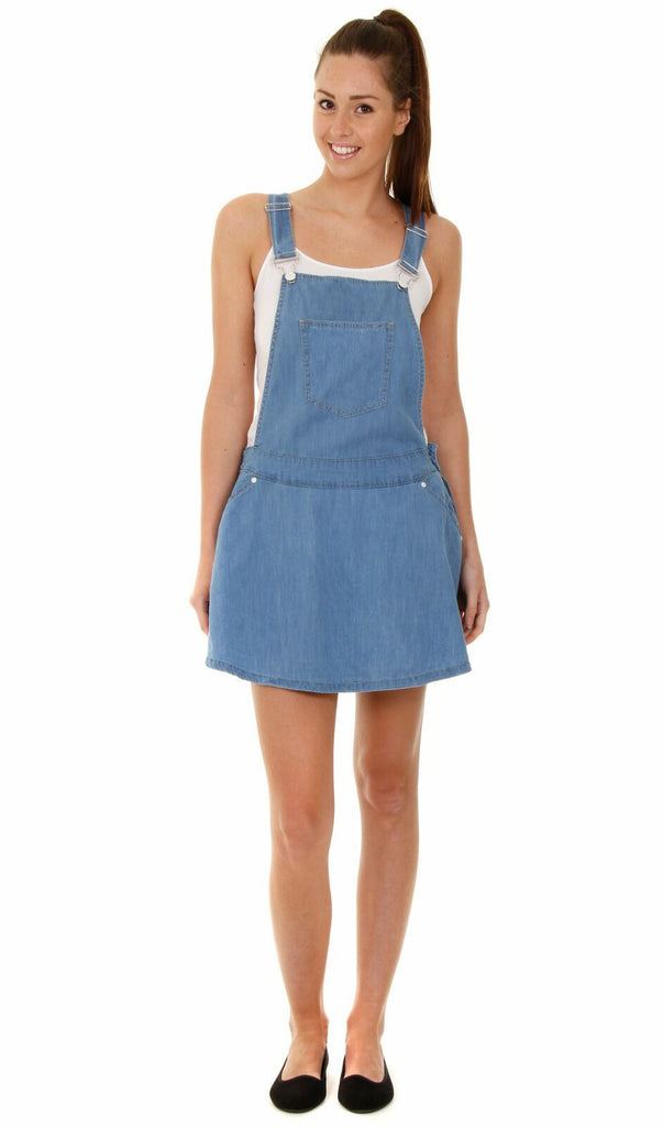 Full length front shot of mini dungaree skater dress in lightweight denim with view of bib pocket.