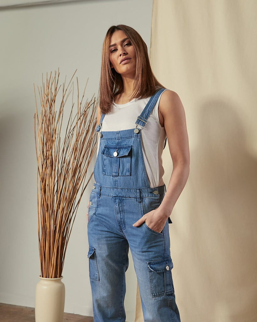 Top two-thirds  view of model wearing Tammy stonewash bib-overalls with view of large bib pocket.