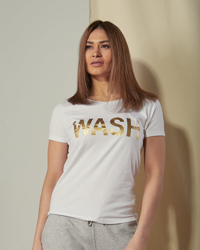 Front view of model wearing 'Wash' motif t-shirt in white organic cotton.